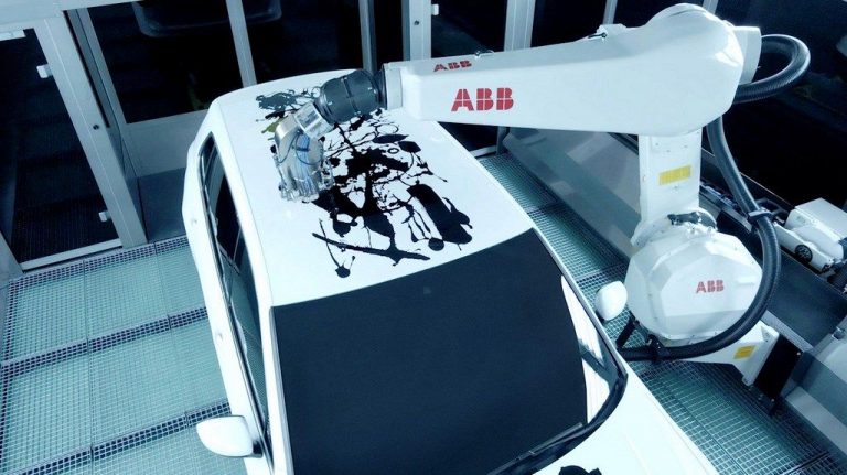 Роботи цртаат уметничко дело врз покривот на автомобилот